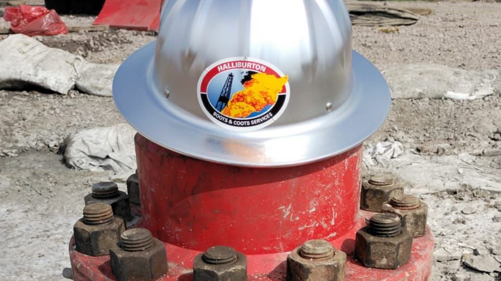 Hardhat with Boots & Coots logo on wellhead.