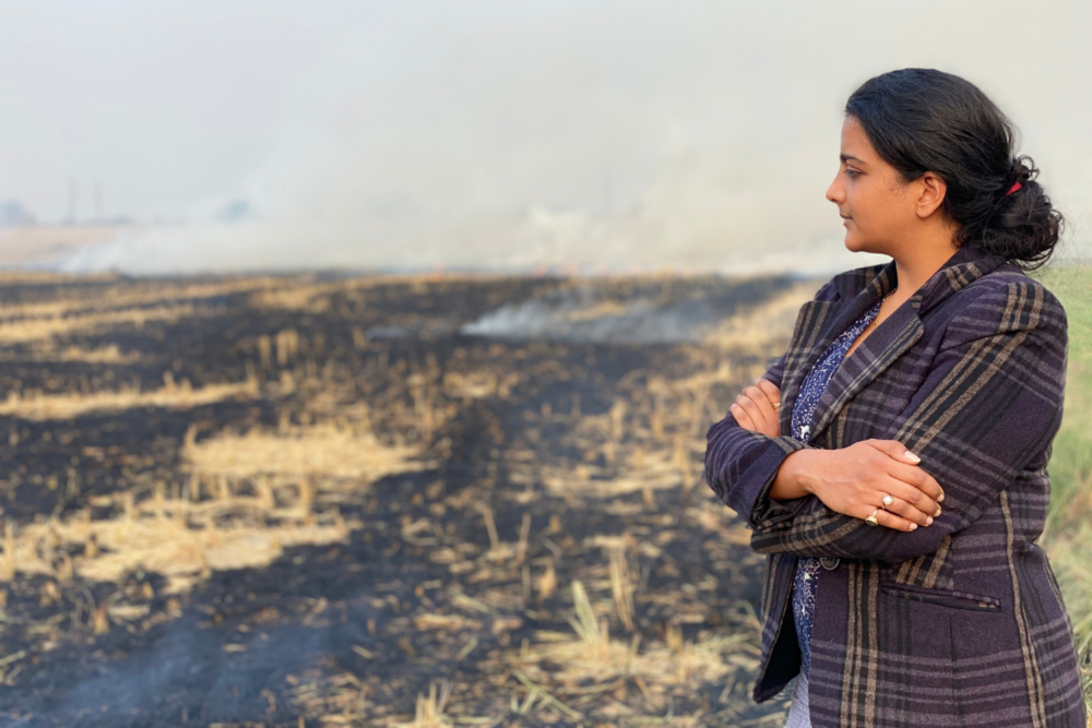 Craste founder Dr. Himansha Singh with a field of burning crops