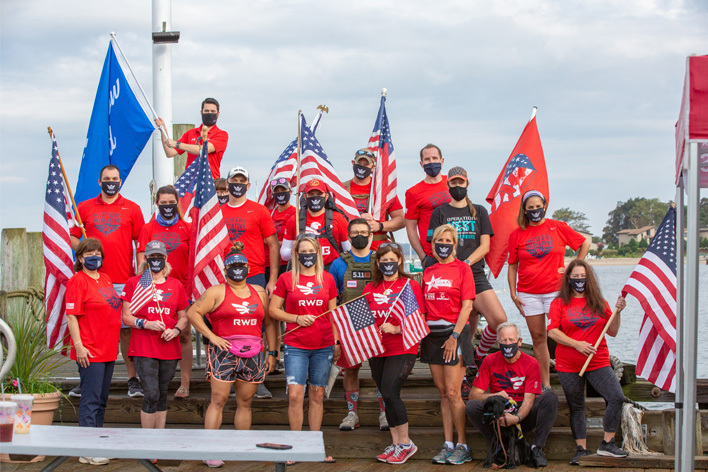 Group of Team RWB members and Window World employees posing with American flag