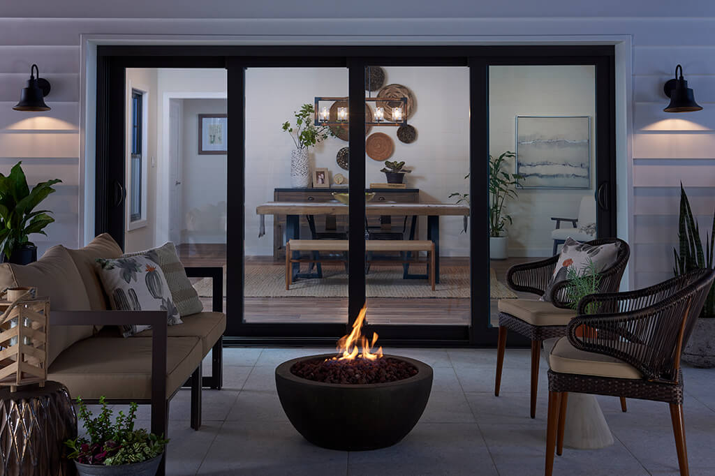 Outside living room with fireplace in front of big sliding doors, used as patio window