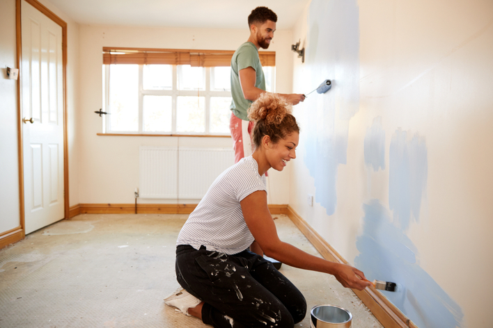 Young couple painting their home
