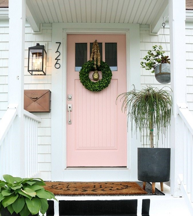 Coral-colored front door with white surround