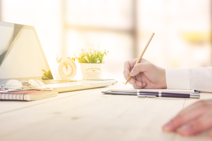 Man writing and planning at home desk