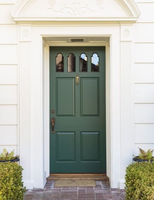 Dark green front door on a white house