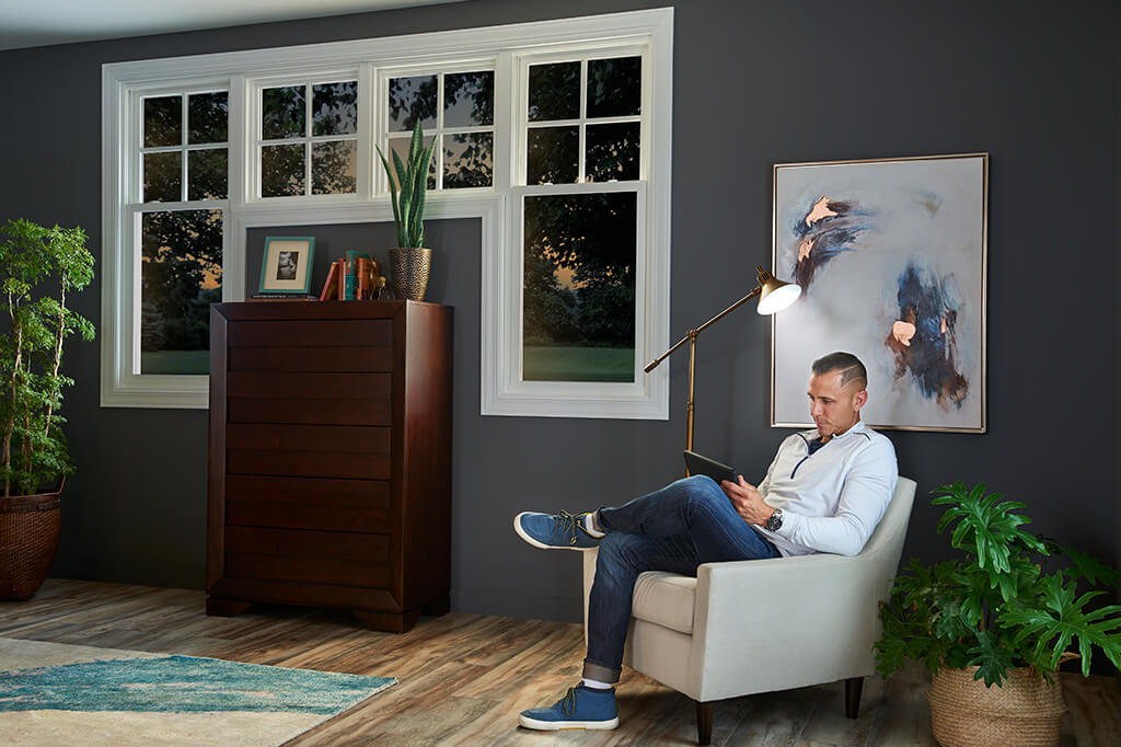 Person reading quietly in a room with big windows