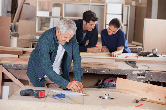 Couple reviewing remodeling plans with a contractor