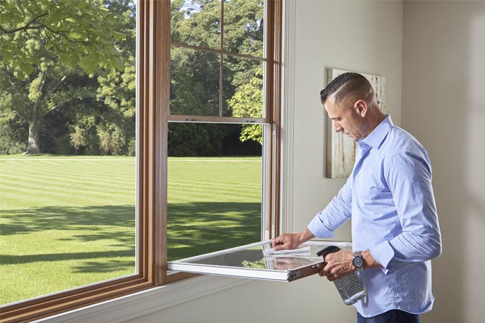 Man cleaning a double-hung window