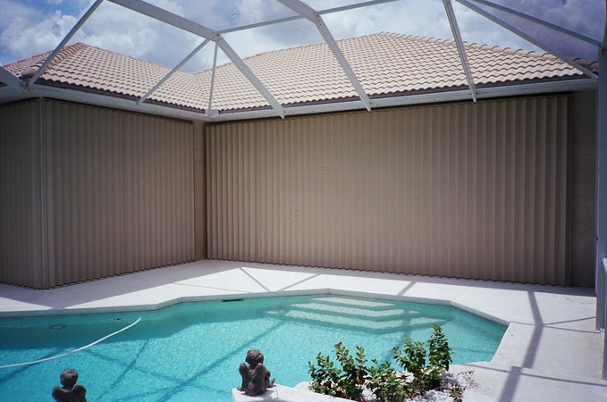 Indoor pool featuring accordion shutters covering patio doors and windows