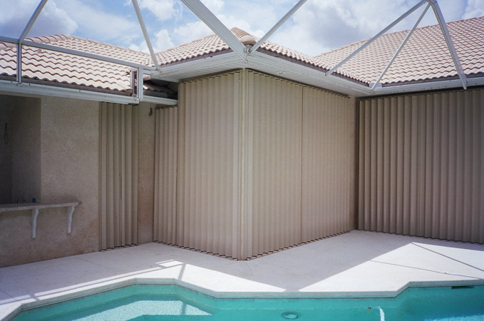 Different view of indoor pool with accordion shutters covering patio doors and windows 