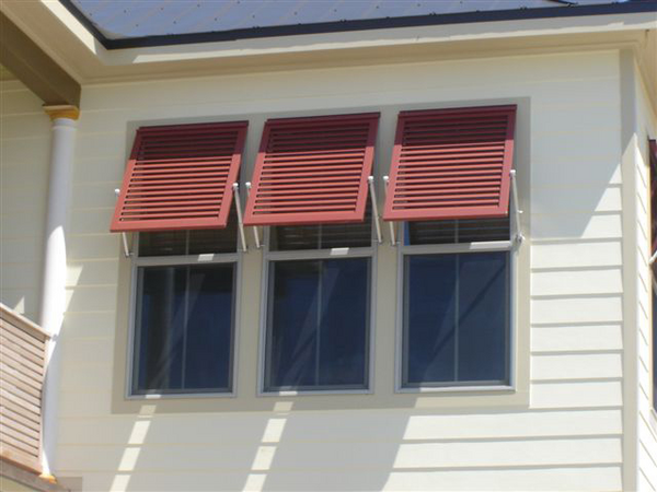 White house with Red Bahama Shutters on windows