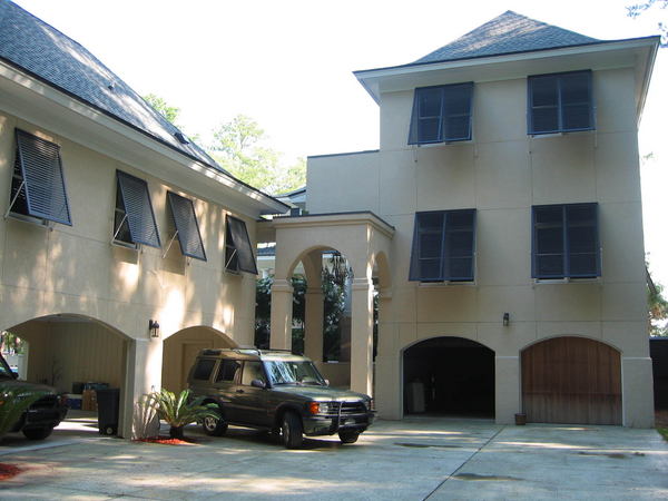 Large white house with Bahama Shutters on windows