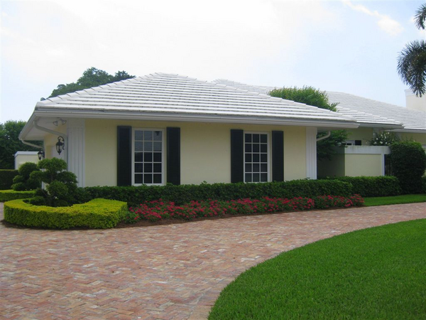 Black raised panel Colonial Shutters on an yellow-colored house