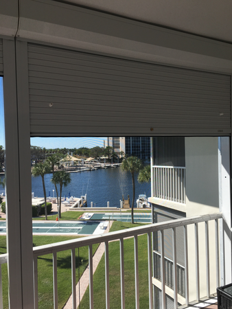 Roll Shutters partially covering a patio of a condominium overlooking a marina