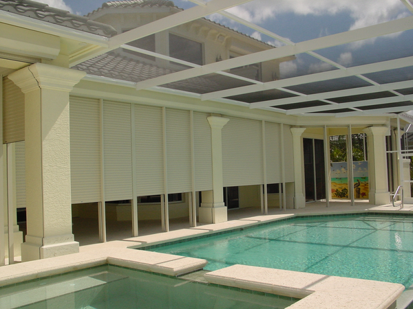 White Roll Shutters partially covering a indoor pool's patio