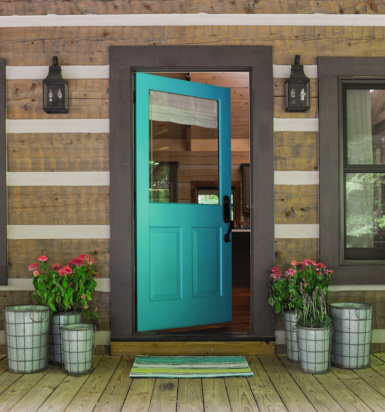 Bright teal-colored door on a log cabin 