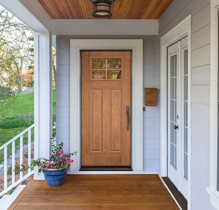 A light woodgrain door on a pastel front porch