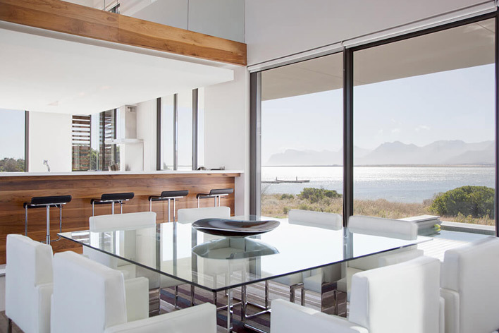 A room facing the sea with floor to ceiling windows 