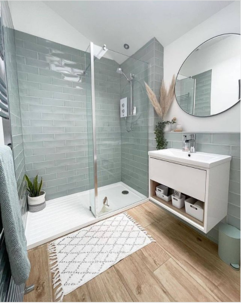 A green tile shower in a charming beach-inspired bathroom