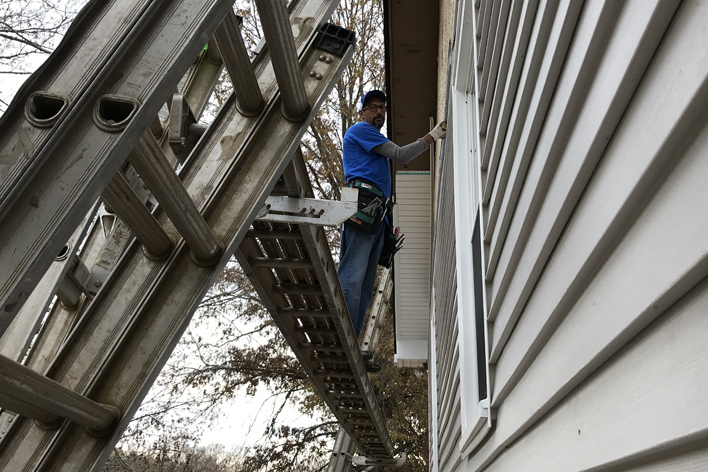 Man installing vinyl siding on a home