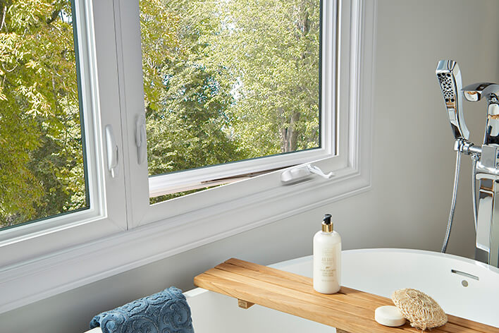 The bathroom of a ranch home is remodeled with casement windows beside the soaking tub