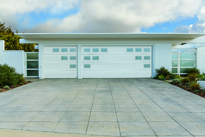 A mid-century modern home with a garage door that includes a geometric design for modern curb appeal