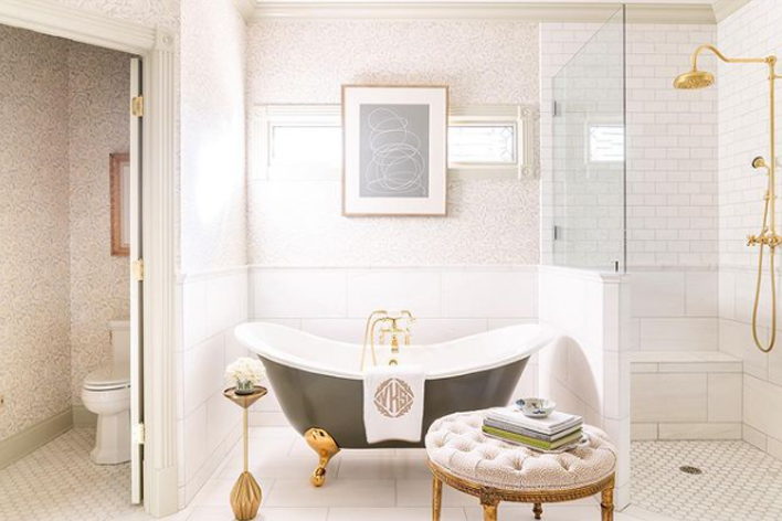 A large ornate bathroom with clawfoot tub and white design elements