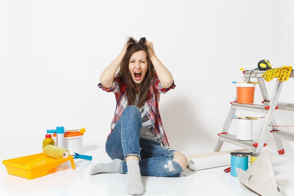 A stressed woman doing DIY home repairs