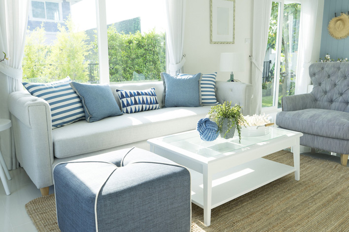 A living room in coastal tones and large windows