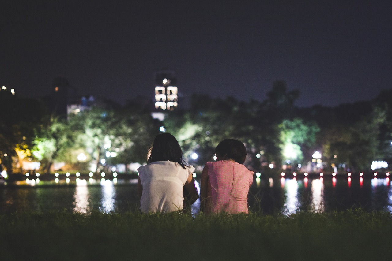 two people sitting by the waterfront