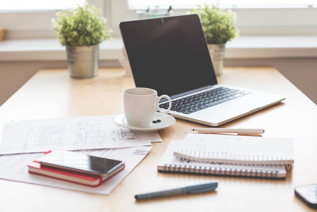 desk workspace with computer and notebooks