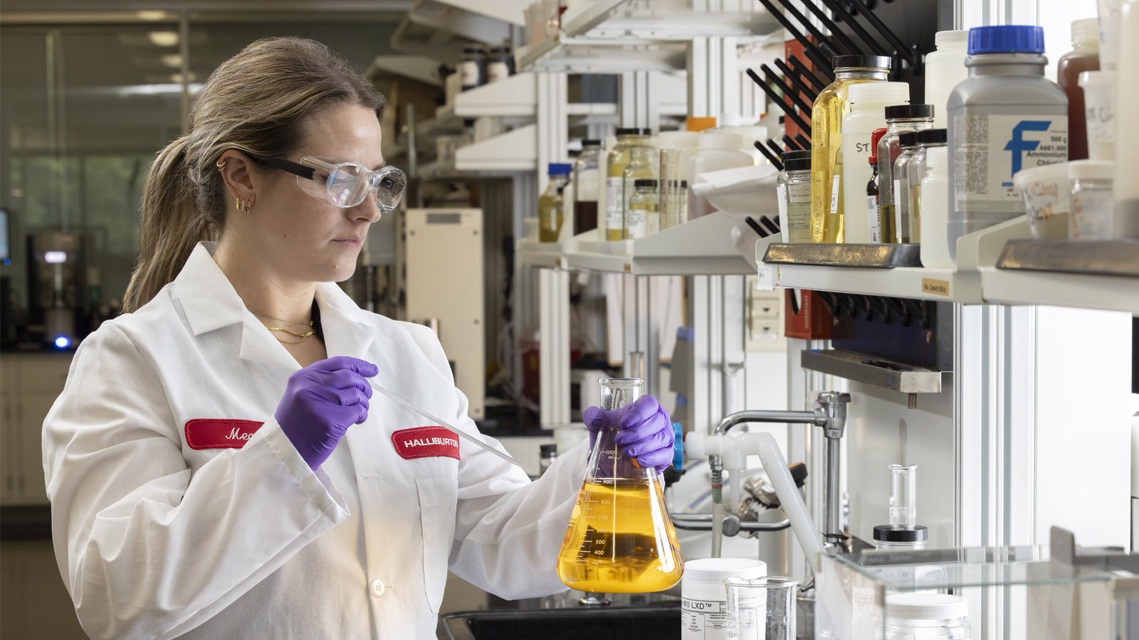 Multi-Cide biocide treatment in lab test tube handled by Halliburton lab technician
