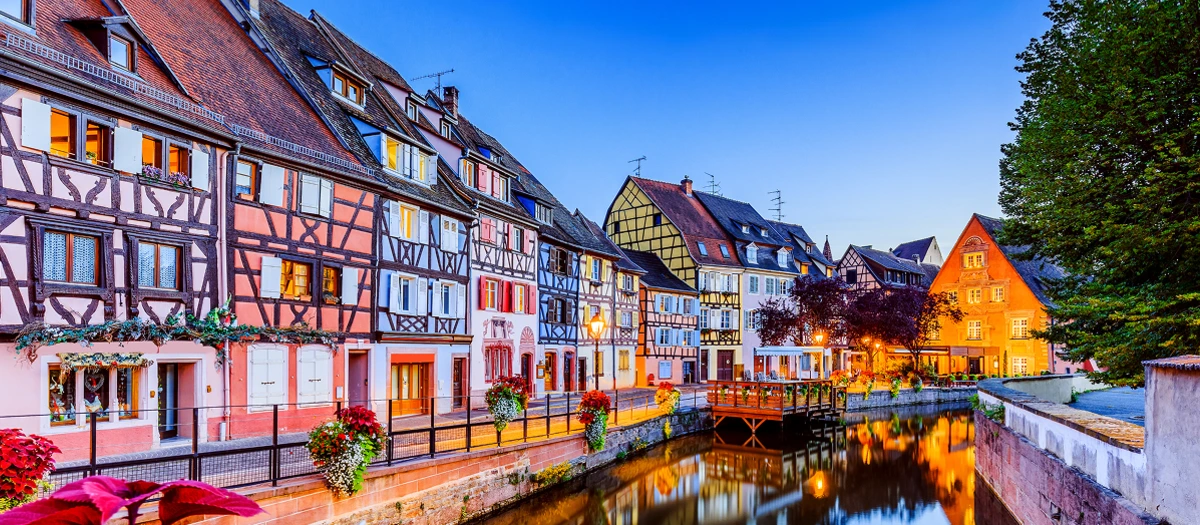 Medieval era buildings along a river in a town in France.