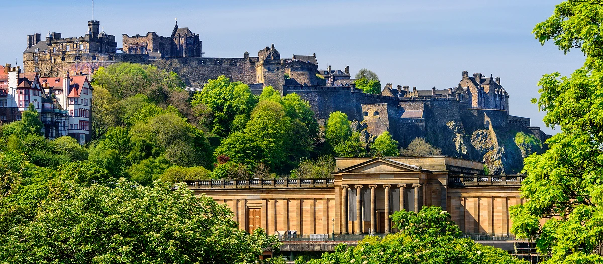 Edinburgh Castle above the city gardens and galleries on England and Scotland student tours.