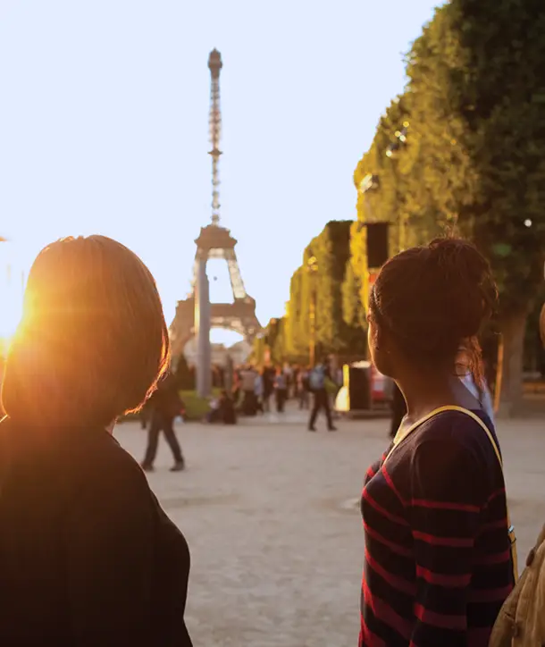 Students looking-on to Eiffel Tower in sunset.