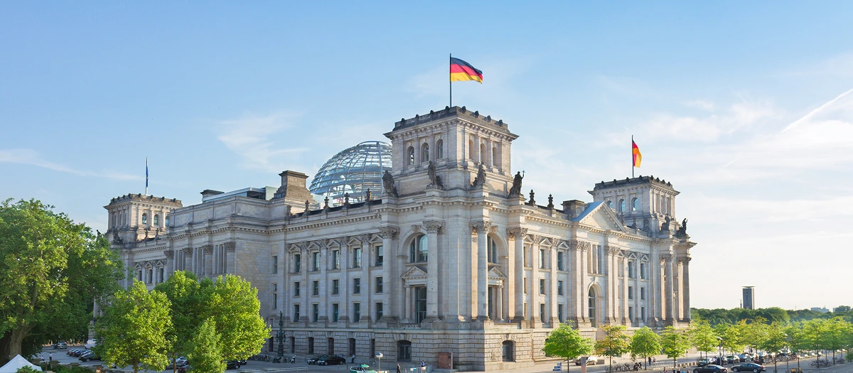 Reichstag building and German flags in Berlin on Berlin, Prague and the Alps student tours.