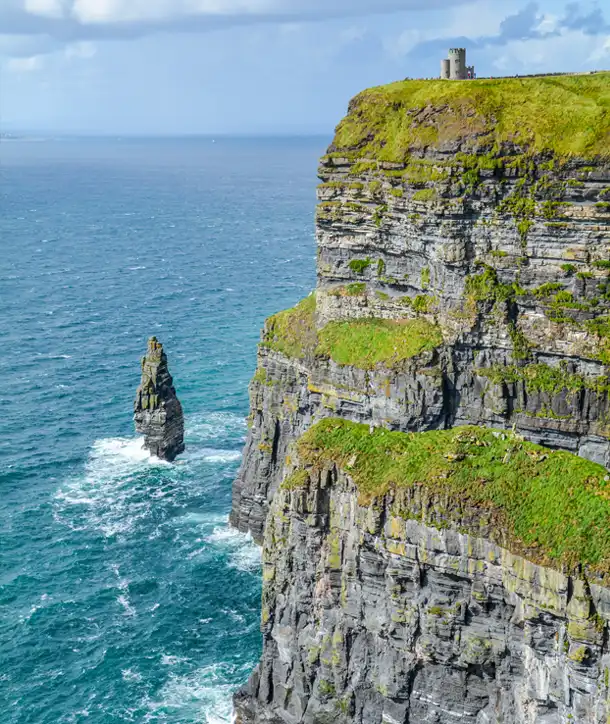 Zoomed-in look at Cliffs of Moher with castle on a hill.