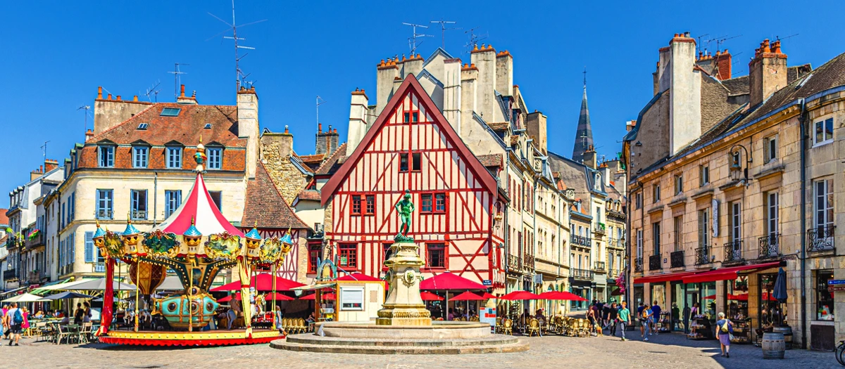 Carousel and half-timbered houses in a European town square on the Essence of Europe tour.