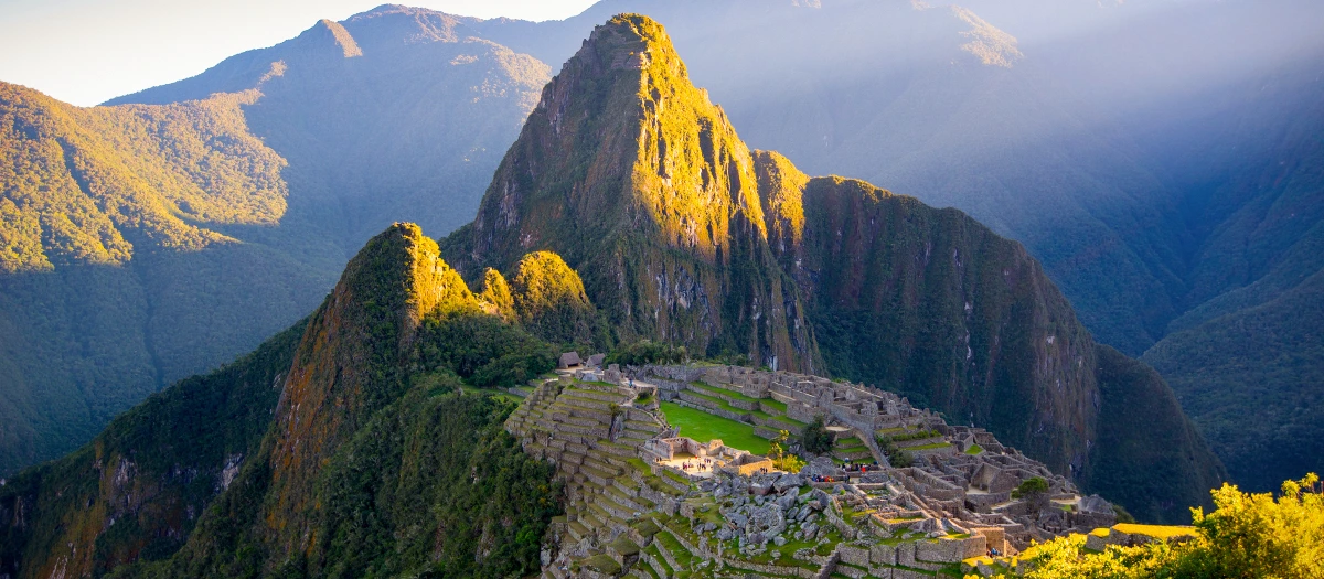 Machu Picchu terraces below Huayna Picchu lit by morning sun on the Heights of Peru tour.