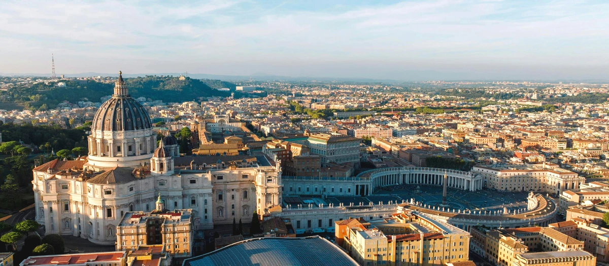 St Peter's Basilica and the Vatican above the rooftops of Rome on France and Italy tours.