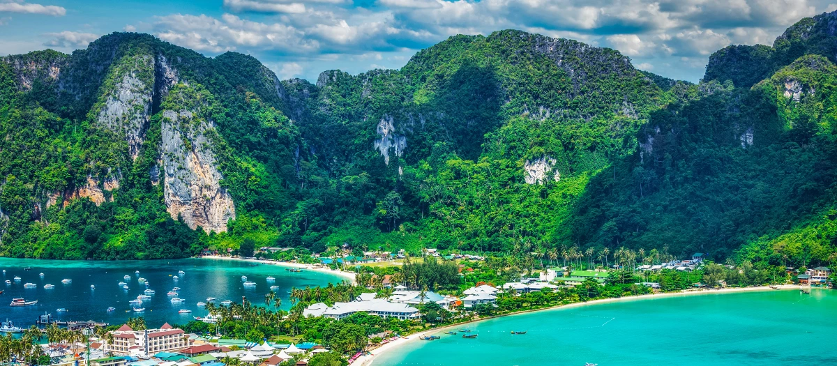 Limestone karsts above a turquoise bay in southern Thailand on a coastal conservation tour.