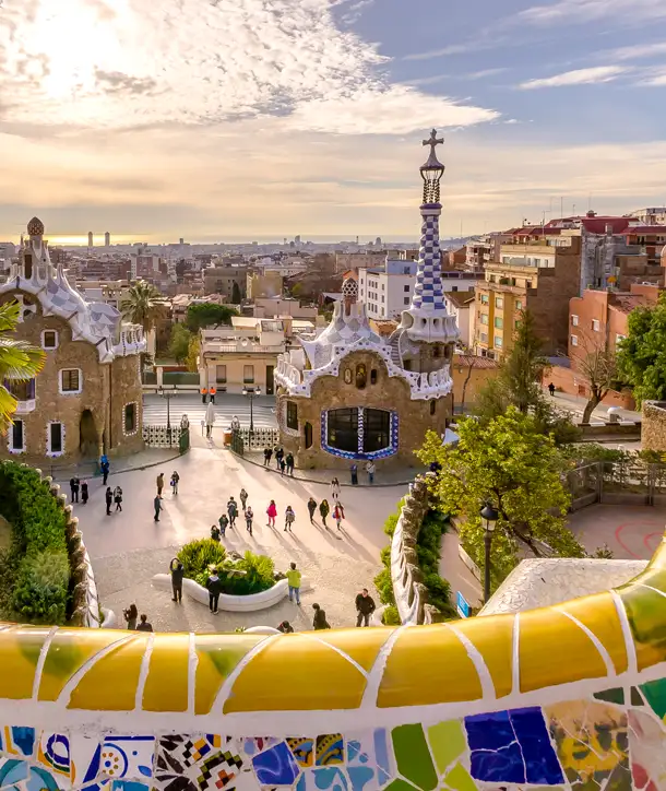 View of Park Güell with unique architecture and sunset in the background.