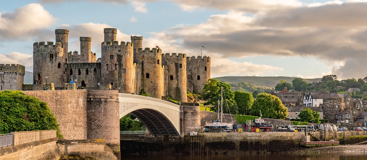 Medieval castle above a harbour in Wales on England, Ireland and Wales student tours.