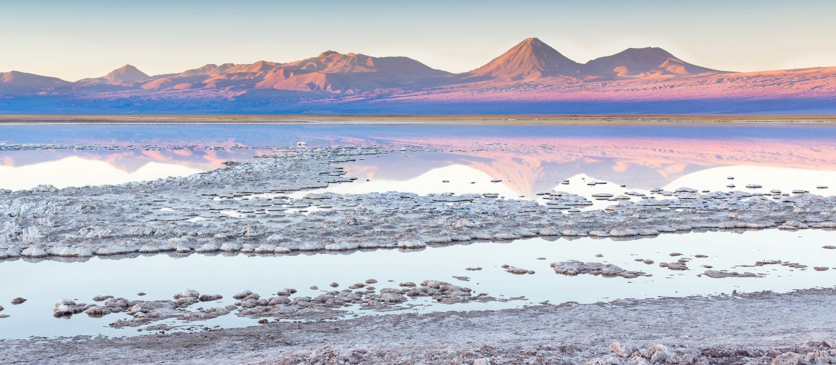 Salt flats below distant mountains at dawn on tours of Chile and Argentina for students.