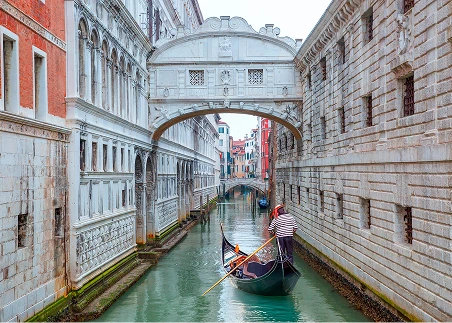 Glide through Venice’s winding canals on a gondola ride, where grand palazzos and ancient bridges line every turn