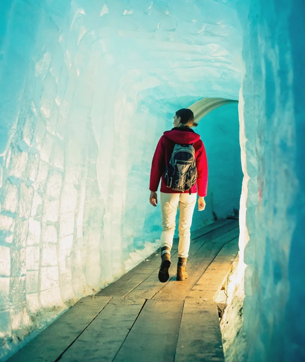 Woman walking through ice tunnel while on tour in Germany.