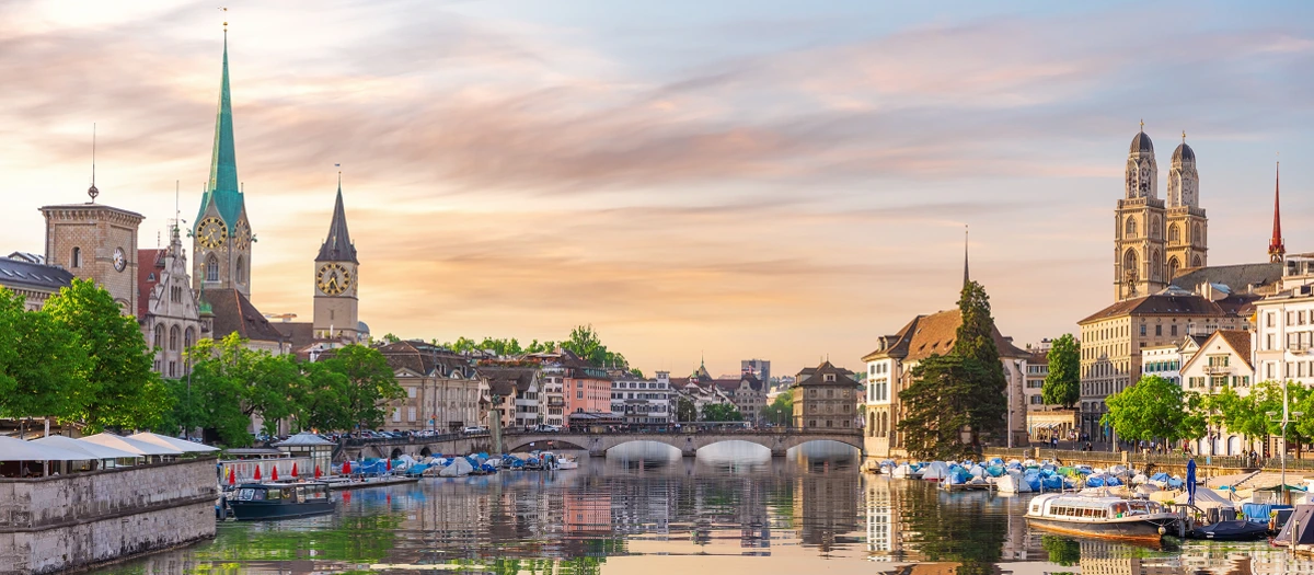 Riverside church spires and old town buildings in Zurich on tours of Central Europe.