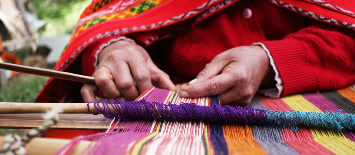 Woman in Peru engaging in traditional weaving.