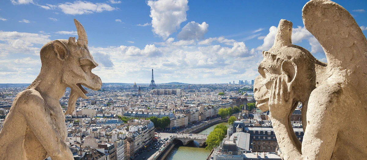 Stone gargoyles looking out over Paris and the Eiffel Tower on a Paris, Florence and Venice trip.