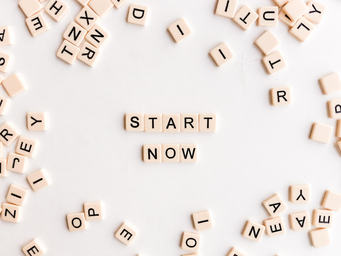 scrabble tiles spelling out \"start now\"