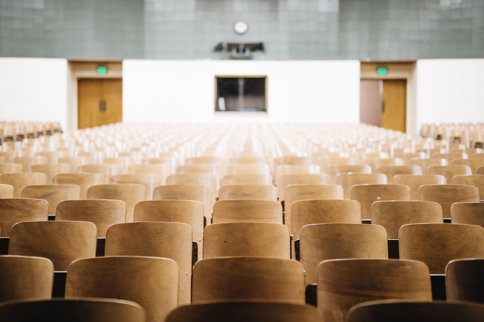 empty lecture hall with wooden chairs